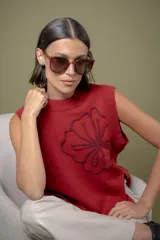 Chaleco de punto color rojo, con diseño de flor bordada en relieve en el frente y aberturas laterales en el ruedo.