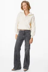 Sweater de tejido acolchado con diseño de rombos, color beige, con cuello polo y cierre frontal parcial. Presenta puños y cuello en tejido acanalado, con mangas largas y corte cropped.