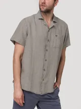 Camisa de manga corta color gris, de corte regular y estilo casual, confeccionada en lino orgánico con cuello sastre y cierre frontal de botones.