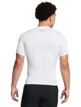 Remera de compresión Under Armour HeatGear de manga corta, diseñada para entrenamiento de alto rendimiento. Presenta un ajuste ceñido al cuerpo, paneles de malla estratégicos para ventilación en axilas y espalda, y mangas raglán híbridas para mayor libertad de movimiento.