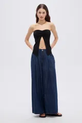 Top de viscosa negro, sin mangas, con escote strapless y frunce central en el escote que genera una abertura frontal.