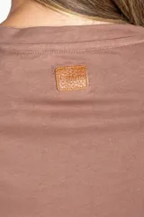 Remera negra de algodón con mangas cortas abullonadas que presentan detalles de encaje bordado y calado en los extremos.