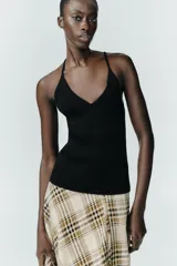 Top negro de punto con escote en pico y tirantes finos.