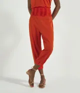 Pantalón jogger color naranja, de tiro alto con cintura ancha fruncida y elástica, bolsillos traseros y botamangas con elástico.