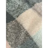 Bufanda rectangular de tejido grueso con diseño de cuadros en tonos azul, naranja, gris y beige, terminada con flecos en los extremos.