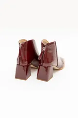 Botinetas de cuero charolado color negro, con taco cuadrado de 6,5 cm, punta cuadrada y diseño de corte en V en el empeine.