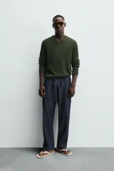 Jersey de punto color verde oliva, de corte regular fit, con cuello en V y manga larga.