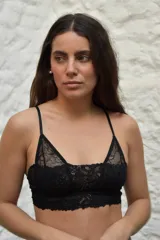 Bralette negro de puntilla sin aro ni relleno, con elástico bajo el busto, tirantes regulables y cierre trasero.