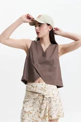 Chaleco corto color marrón topo, con escote en V asimétrico y cierre cruzado con botones.