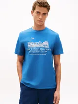 Remera de punto grueso color azul, de corte regular y cuello redondo. Presenta un bordado frontal en tono claro con la ilustración de un club de campo y el texto "The Tommy Hilfiger Country Club".