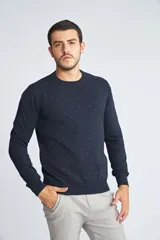 Sweater de punto color mostaza con cuello redondo y mangas largas. Presenta un estampado de pequeños motivos repetidos en contraste y un logo bordado en el pecho.
