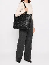 Cartera tote de diseño amplio y elegante, marca Sagali, confeccionada en cuero con textura tramada que aporta un acabado distintivo. Cuenta con asas largas para llevar al hombro y placa metálica con el logo grabado en el frente.