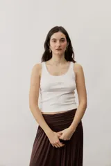 Musculosa de tejido rib color beige con detalles marrones en los bordes del cuello y sisas. Cuenta con el logotipo de la marca bordado en el pecho.