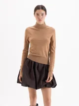 Polera de tejido fino con cuello alto, manga larga y calce entallado al cuerpo.
