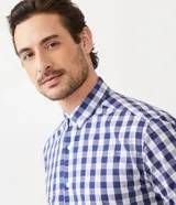 Camisa de manga corta con estampado de cuadros azules y blancos. Fabricada con una mezcla de algodón y poliéster, la pieza es transpirable y no se arruga fácilmente.