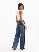 Jeans Roses Bow de tiro medio y calce holgado, con pierna amplia y lavado azul intermedio. Cuenta con recortes laterales en contraste y detalles de lazos regulables en los tobillos.