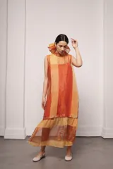 Vestido largo color ocre con estampado de cuadrados dorados, cuello alto y corte amplio. Incluye viso liso al tono.