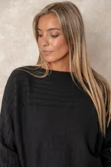 Buzo de punto color azul petróleo, con cuello redondo, mangas largas con puños ajustados y detalles de textura trenzada en la parte superior y el ruedo.