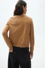 Saco de punto fino con cuello redondo, cierre frontal con botones y terminaciones acanaladas en puños y bajo.