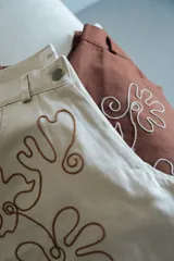 Pantalón slouchy color beige de gabardina de algodón con bordado floral marrón.