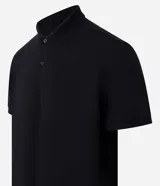 Remera polo de manga corta color verde militar, confeccionada en algodón peruano con cuello convencional y cierre de botones.