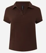 Blusa de algodón color marrón, con cuello polo, escote en V y manga corta. Diseño ajustado al cuerpo.