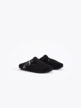 Zueco negro de pelo vacuno, estilo cerrado con abertura en forma de T en el empeine, asegurado con una tira de cuero y hebilla metálica. Incluye un dije metálico con forma de llama en la tira.