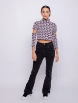 Top corto de tejido con estampado geométrico retro en tonos rosa, gris y negro. Es de manga larga con cut-out en los codos y cuello alto.