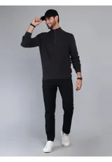 Sweater de punto en color beige, con cuello alto y cierre frontal parcial. Diseño de manga larga con puños y ruedo acanalados.
