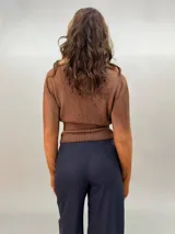 Buzo de punto confeccionado en 100% lana merino con efecto degradé en tonos azules. Presenta un diseño versátil con lazos largos que nacen de la cintura alta para anudar de diferentes formas, mangas entalladas con ojal para el pulgar y cuello redondo.