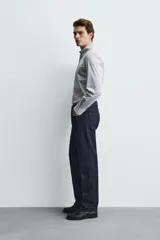Camisa de corte regular fit confeccionada en tejido de algodón con estampado de microcuadros. Presenta cuello abotonado, manga larga con puños abotonados y cierre frontal de botones.