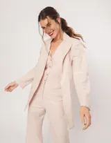 Blazer oversized color beige de corte recto, confeccionado en tela con lino.