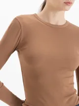Remera de micro rib color blanco, con cuello redondo, mangas largas y silueta ajustada al cuerpo. Presenta logo bordado en la espalda.