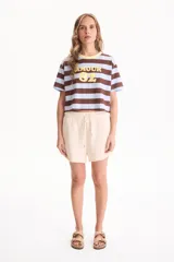 Short deportivo sin friza color beige, con cintura elástica con cordón ajustable, bolsillos laterales y terminaciones deshilachadas.