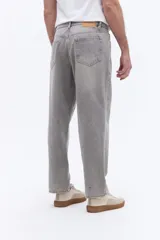 Pantalón de jean con corte baggy, tiro medio y diseño amplio en piernas y cadera. Cuenta con pasacintos y cierre frontal con botón.