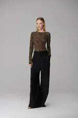 Pantalones de vestir de corte sastrero, con cintura alta, pliegues frontales y pernera ancha y fluida. Cuentan con trabillas para cinturón, bolsillos laterales y bolsillos traseros ribeteados.