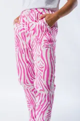 Pantalón babucha con estampado de cebra en fucsia y blanco, corte ajustado, cintura elástica y tejido liviano.