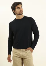 Sweater de punto color naranja, con cuello redondo y mangas raglán.