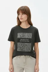 Remera de algodón color negro, con cuello redondo, manga corta y estampa frontal con la frase "The best days are yet to come" y detalles de animal print.
