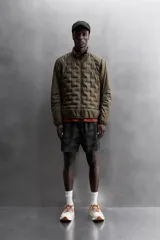 Cazadora deportiva acolchada color verde oscuro, con cuello alto y cierre frontal con cremallera. Cuenta con bolsillos laterales con cremallera oculta y un bolsillo interior.