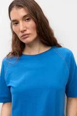Remera blanca de manga corta raglán con detalle de vainillas, cuello redondo y corte clásico.