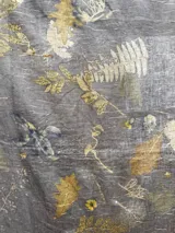 Mantel rectangular de lino color marrón con estampado de hojas y flores en tonos dorados y blancos.