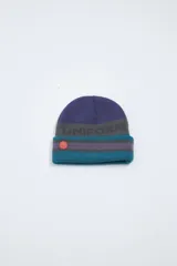 Gorro de lana tejido con diseño a rayas horizontales en azul, gris y turquesa. Incluye un parche circular de goma color naranja.