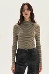 Polera de manga larga con cuello alto, confeccionada en tejido de punto acanalado con diseño de rayas horizontales en color marrón y turquesa. Presenta un bordado pequeño en el pecho y un calce ajustado al cuerpo.