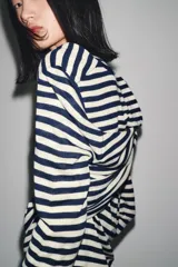 Jersey de punto con cuello redondo y manga larga, con estampado de rayas horizontales blancas y azul marino.