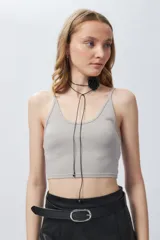 Top corto gris de breteles finos, elastizado y con fibras metálicas brillantes.