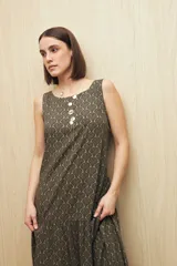 Vestido largo sin mangas color azul marino con estampado paisley en tonos rosados y blancos. Presenta escote redondo, silueta amplia y fluida con volado en el ruedo.