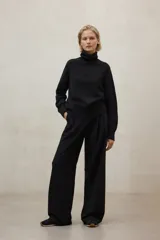 Suéter de cuello alto, color negro, de tejido de punto liso y corte holgado.