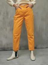 Jeans mom de color naranja, confeccionado en denim, con tiro alto y corte ligeramente holgado que se estrecha hacia los tobillos.