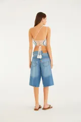 Bermuda de denim color celeste, de tiro medio, con diseño amplio estilo jorts y bolsillos laterales de estilo cargo.